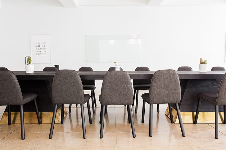 black armless chairs facing black wooden conference table