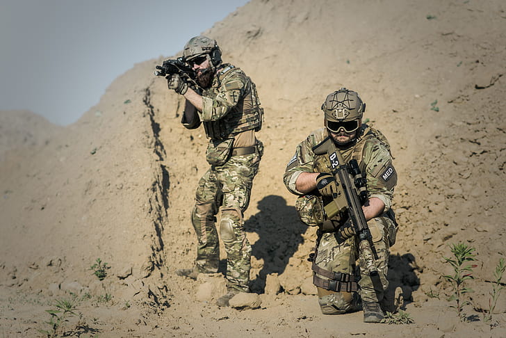 two soldiers with weapons at the field during day