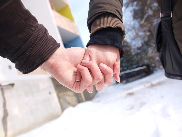 two person holding hands during daytime