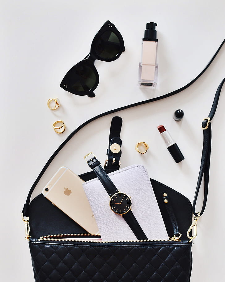 black sunglasses beside lipstick and bag