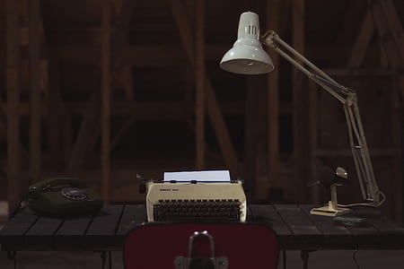 white gooseneck lamp beside type writer
