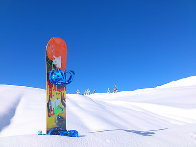 orange and yellow snowboard on snow