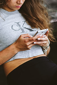 Young woman holding the white mobile phone