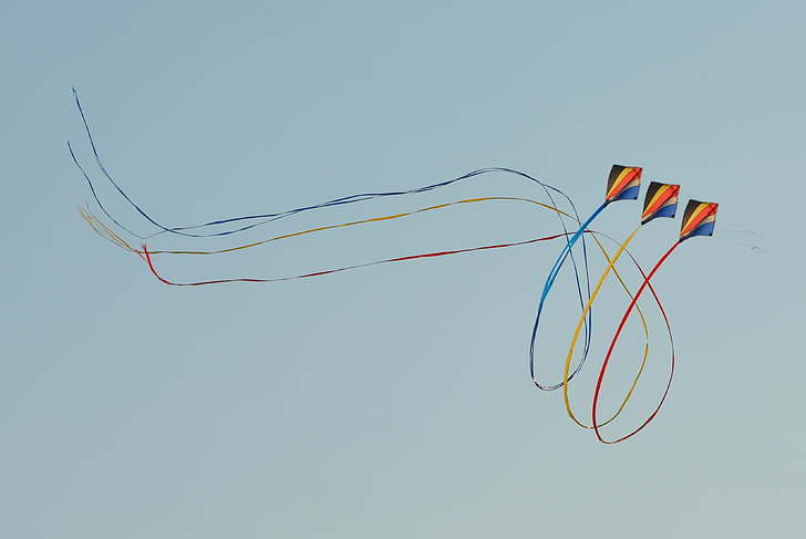 three black-yellow-and-orange kites