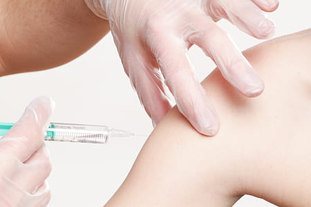 person injecting fluid on persons arm
