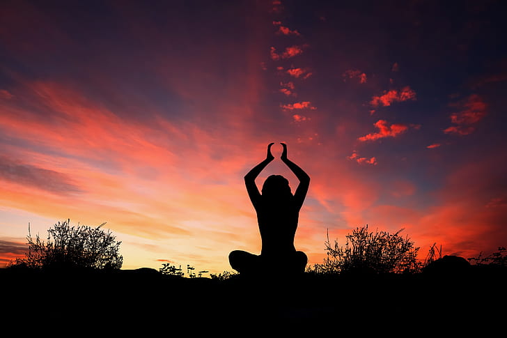 silhouette photography of woman doing yoga during golden hour