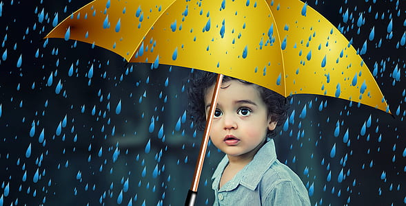 child holding yellow umbrella