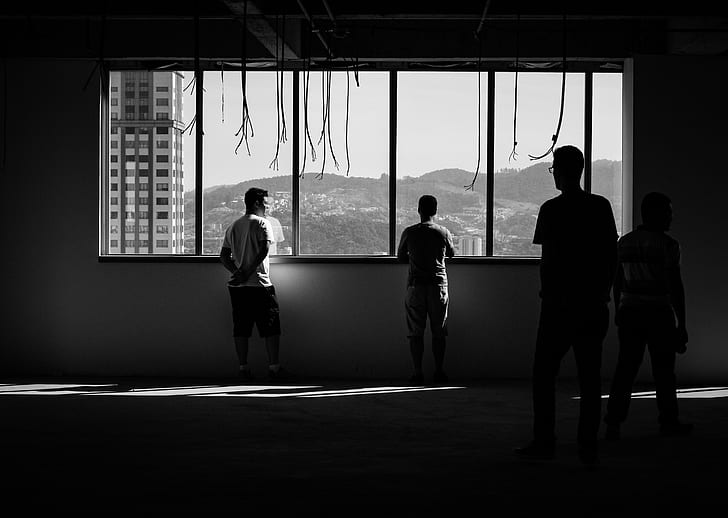 silhouette photo of people standing near window
