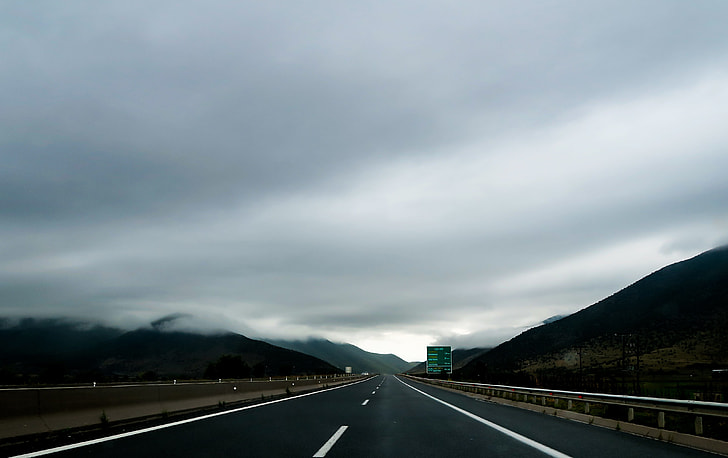 panoramic view of road under the cloudy sky