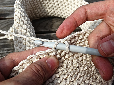 person knitting white textile