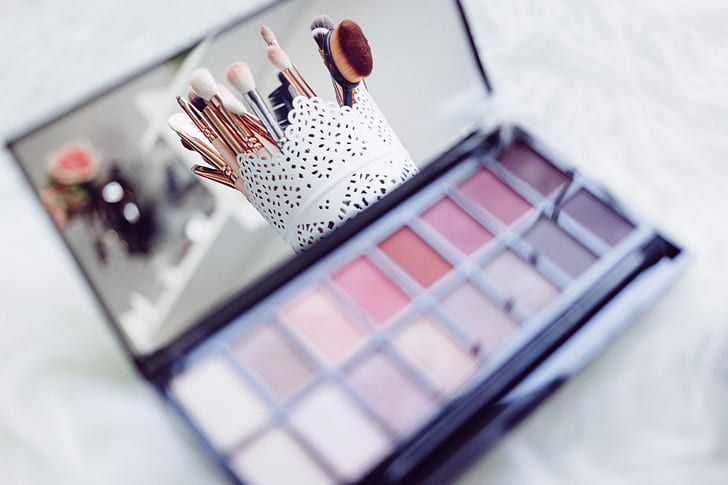 makeup palette with makeup brush set reflected on mirror