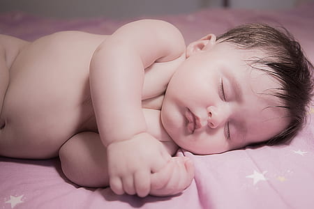 sleeping baby on pink and white star graphic sheet