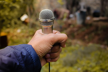 Person Holding Grey Corded Microphone in Selective Focus Photography Photo Taken