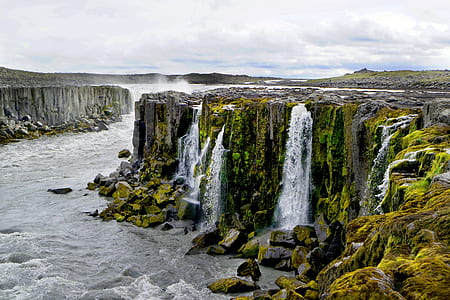 waterfalls surrounded by rock formation