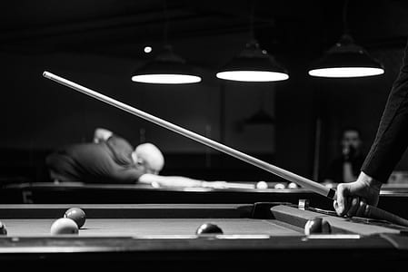 Grayscale Photo of Man Holding Cue-stick