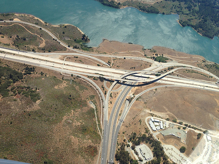 aerial photography of road near body of water during daytimer