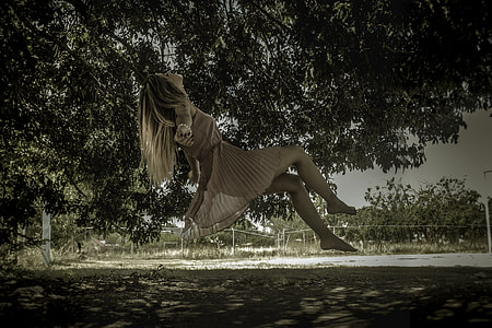 woman riding a tree swing during day time