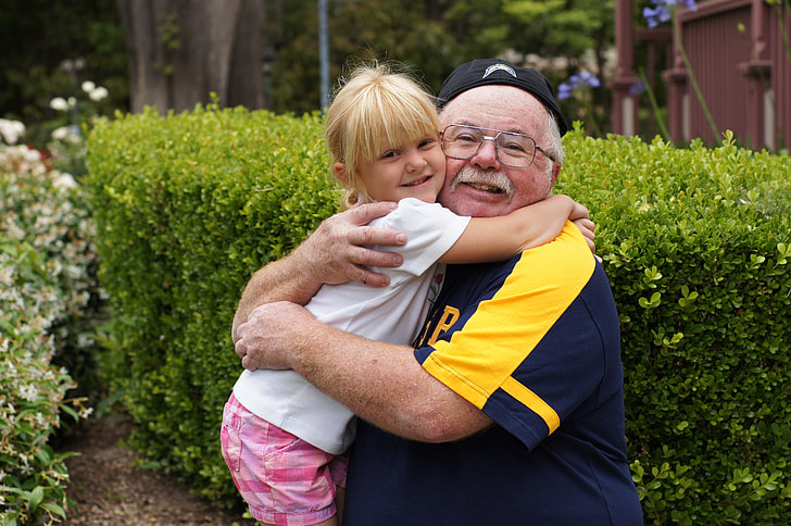 girl hugging her grandfather