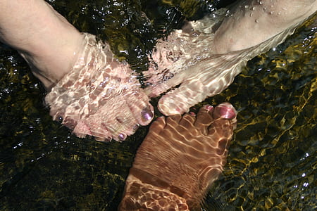 three person's foot on water photography