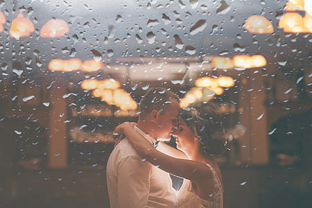 water dew photography of couple standing and about to kiss