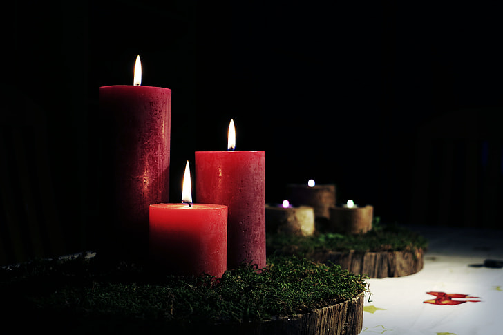 three lighted red pillar candles