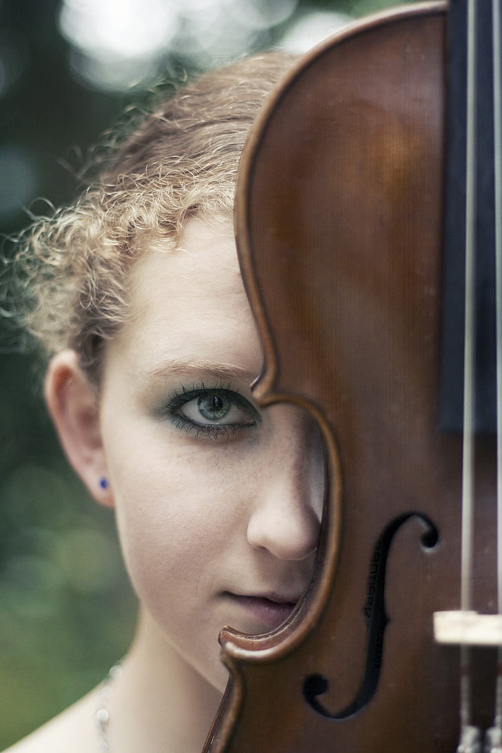 shallow focus photography of woman face with violin