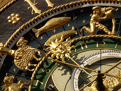 closeup photo of gold-colored and green zodiac sign tower clock