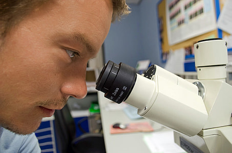 man looking at microscope