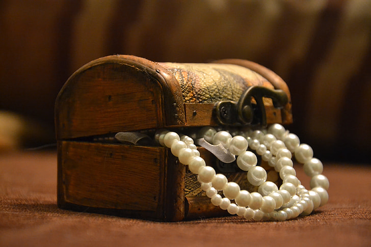 white pearl necklace in brown wooden dome chest