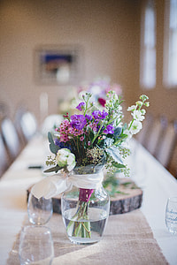 selective focus photography of purple, white, and pink flower centerpiece on clear glass flower vase