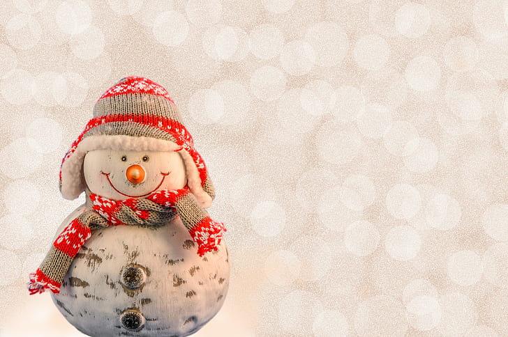 white and red snowman wearing knit hat and scarf figurine