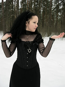 woman wearing black long-sleeved dress at forest surrounded with snow