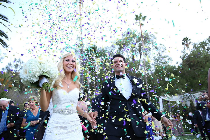 man and woman holding hands under confetti
