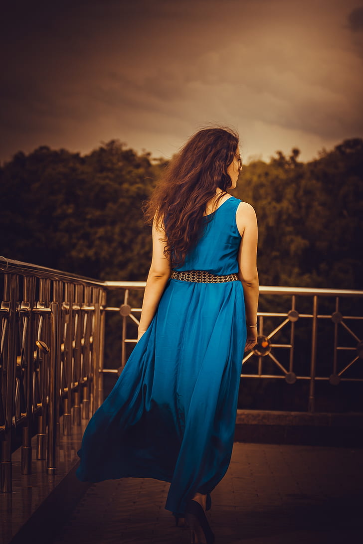 woman wearing blue sleeveless maxi dress