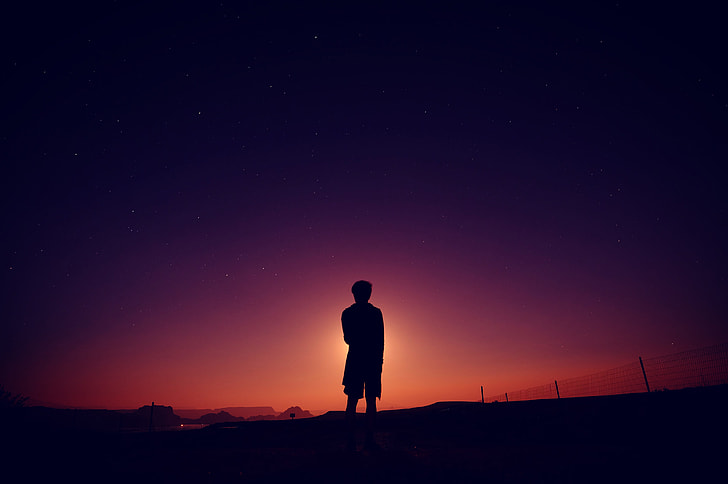 silhouette of man standing during golden hour