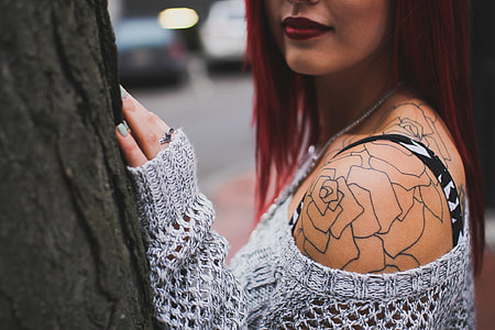 woman in gray off shoulder sweater with shoulder tattoo