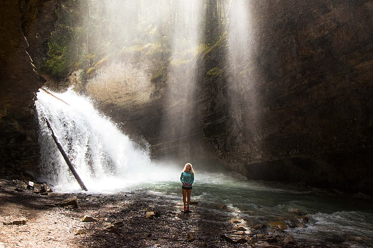 woman standing near waterfalls during daytime