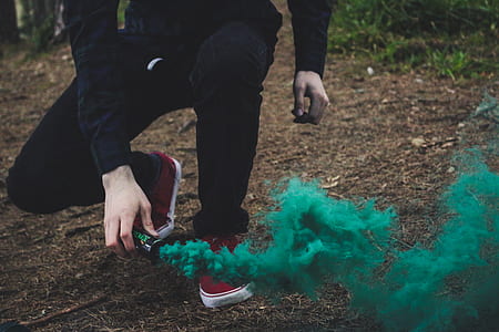 person holding green smoke bomb