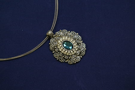 oval green gemstone encrusted gold-colored pendant necklace