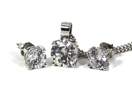 three silver-colored accessories with white crystals