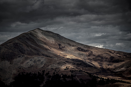 brown mountain under gray clouds