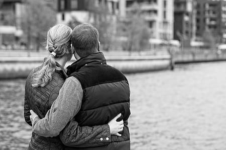 man and woman hugging each other in grayscale photo