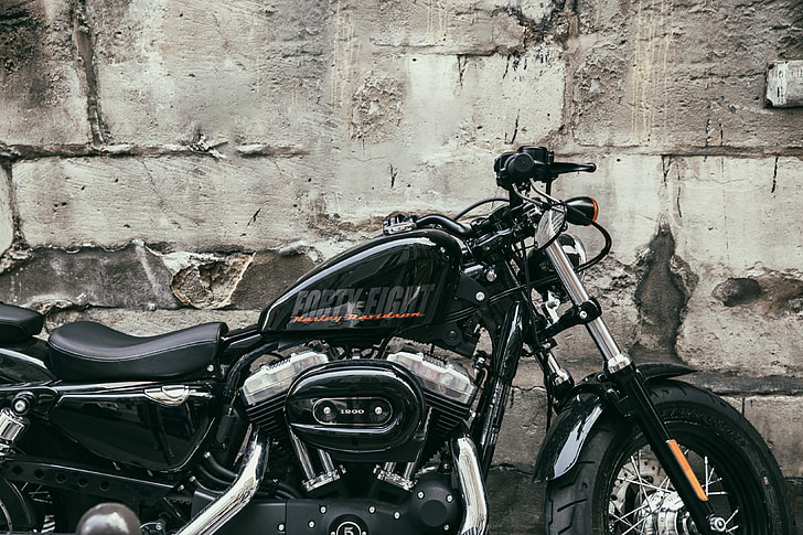 A Harley Davidson motorbike sits by a old wall in Paris, France. Image captured with a Canon 6D
