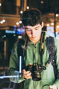 man holding black Nikon DSLR camerea