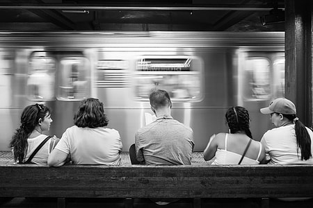 grayscale photo of people sitting on bench