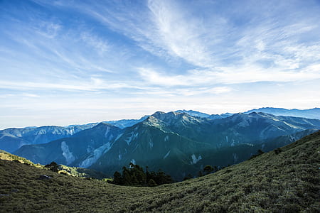 Landscape Photograph of Mountains Under Blue Cloudy Sky
