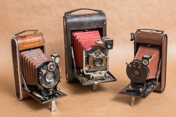 three vintage brown cameras