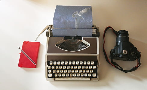 typewriter beside DSLR camera