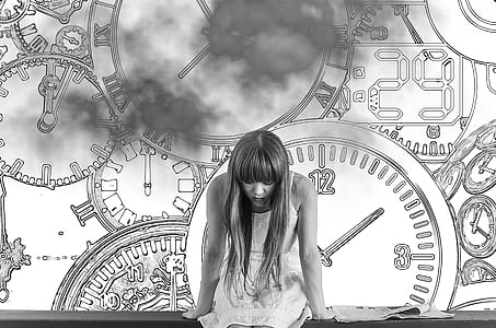 grayscale photo of woman in dress with clocks as background