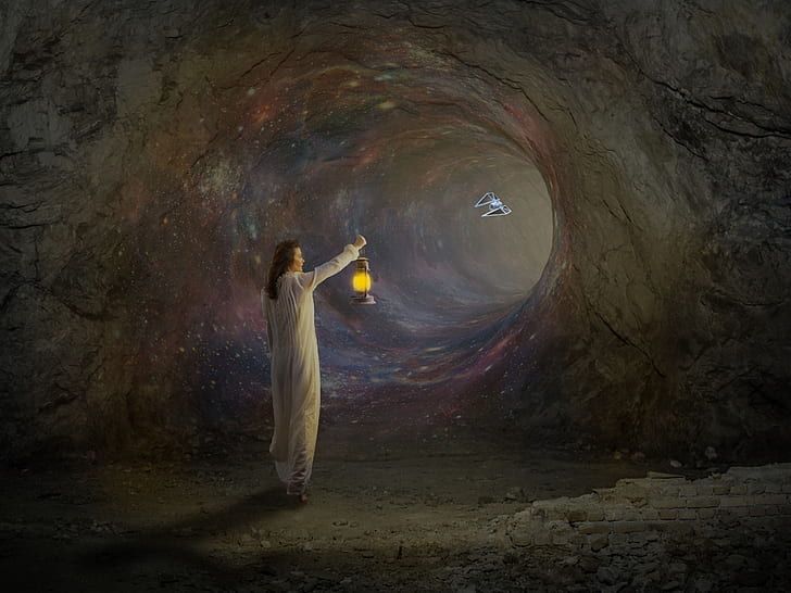 person holding lamp inside cave